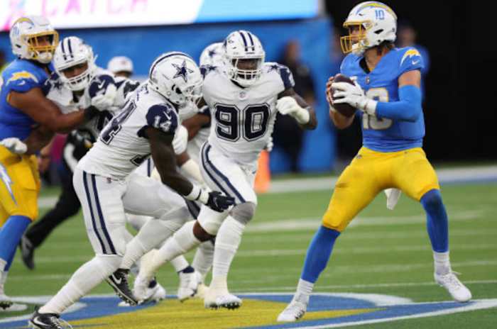 Hebert feels the pressure from two Cowboys defenders.